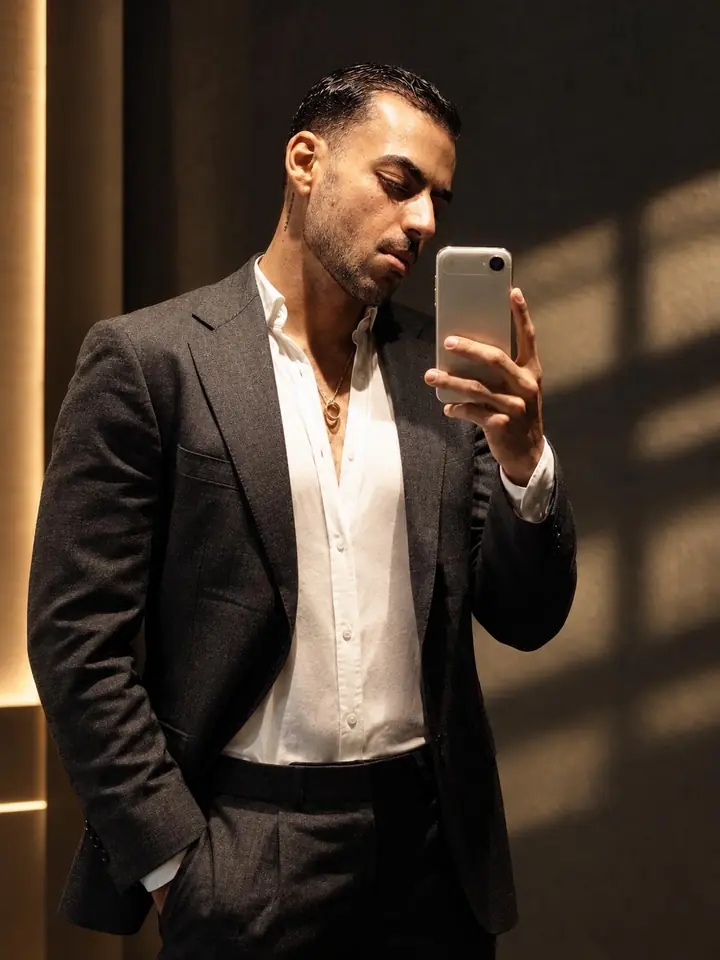 Roei Shirav in a dark suit, phone in hand.